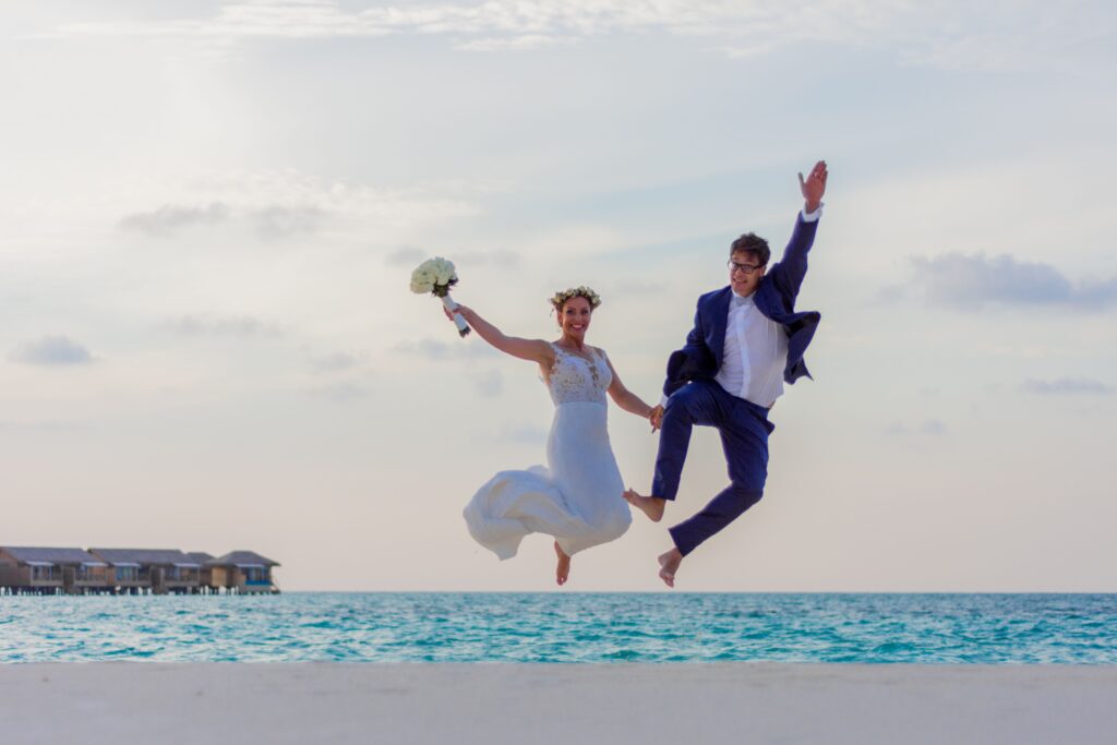 happy newly married couple jumping up for joy